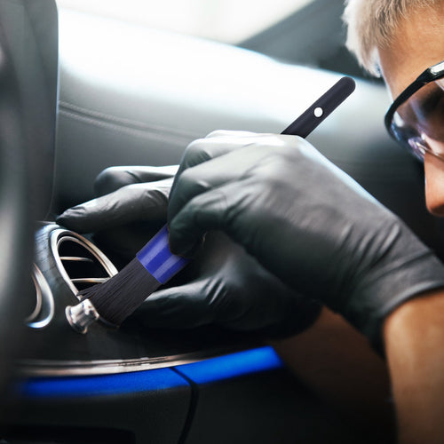 Detailing brush being used to clean a car door speaker grille