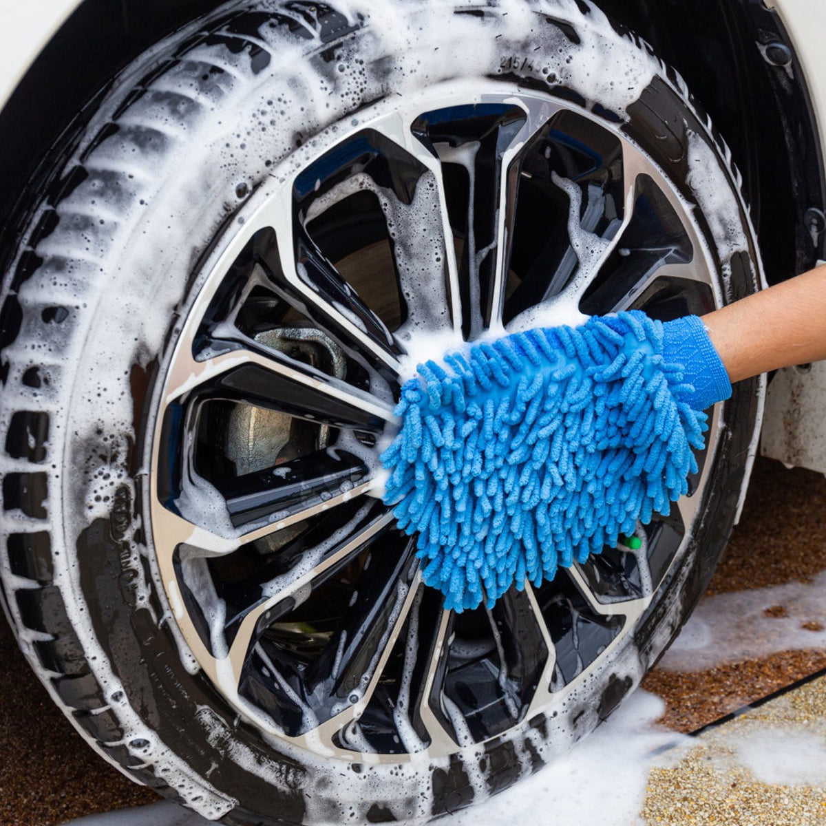 Microfibre wash mitt cleaning a foamy alloy wheel